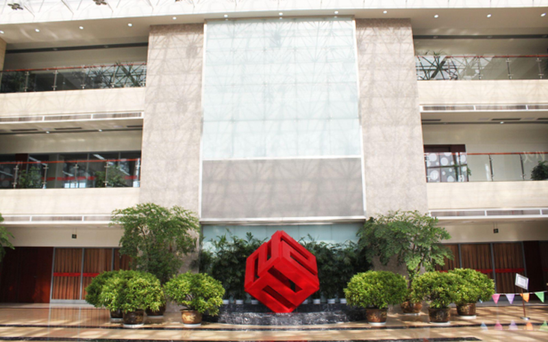 The lobby of FMWorld’s headquarters is spotless and well-lit, with a prominent red cubic logo in the center.