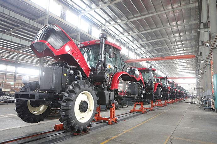 Tractors along an indoor assembly line